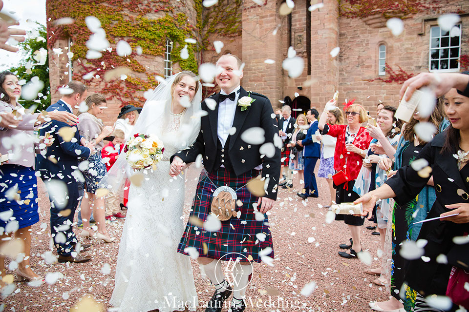 dride and groom with confetti at dalhousie castle scotland