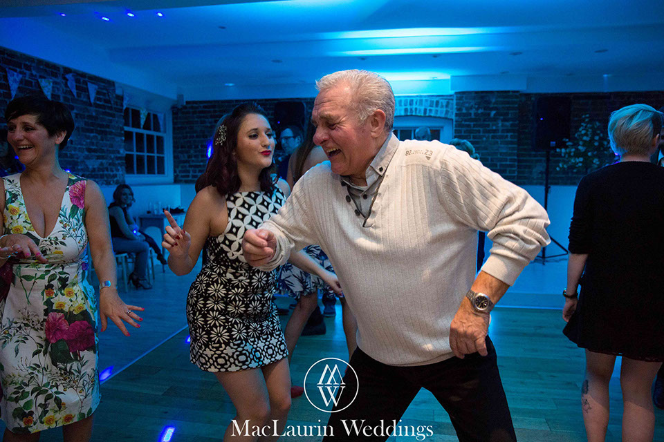 a man in his 60's giving the younger guests some moves