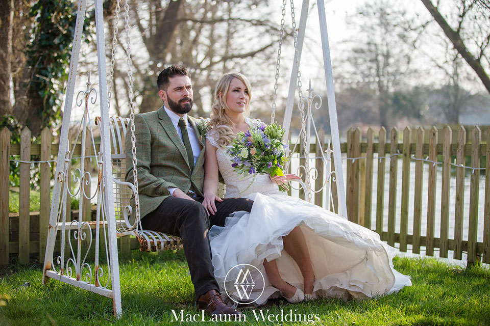 a wedding couple posing on a seat