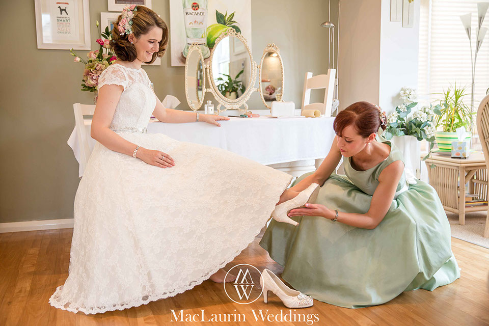 a bride having her shoes fitted before the wedding
