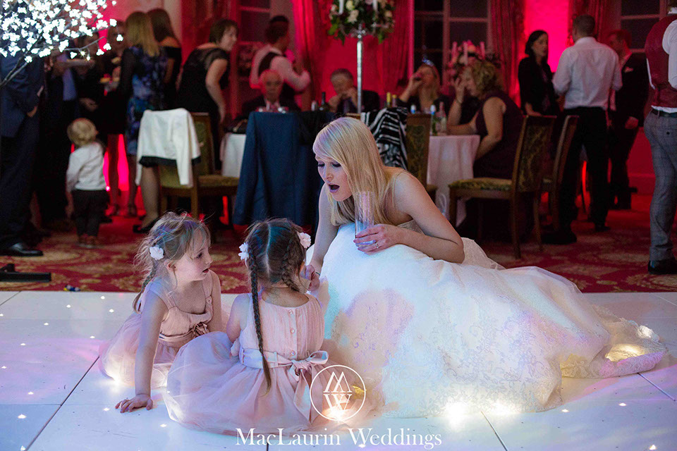 a bride chatting with two girls on the dancefloor