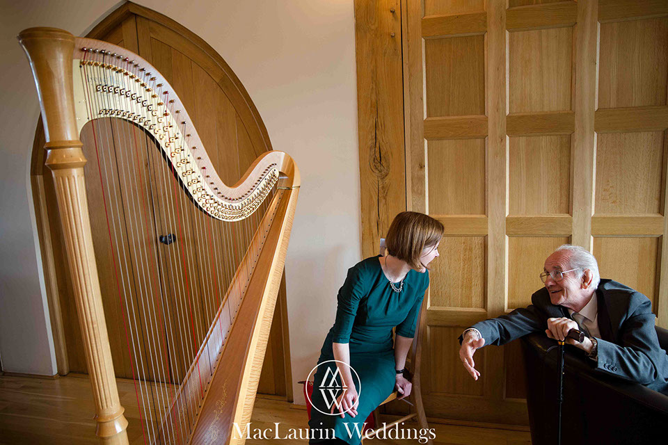 a wedding guest talks with a harpist during her break