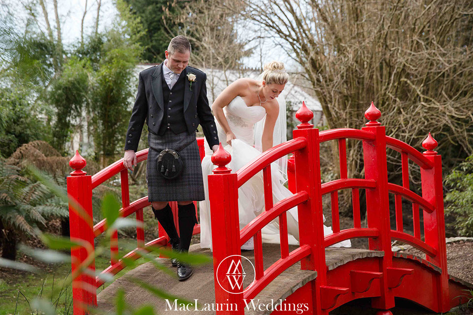a bride and groom walking over a bridge
